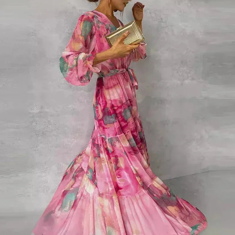 Robe longue longue rose imprimée, manches longues, ceinture évasée, en tissu léger parfait pour les soirées d'été.