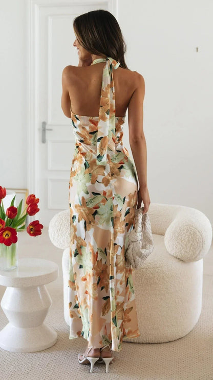Robe longue estivale à motifs floraux, dos nu, col montant, en tissu léger et fluide, parfaite pour les chaudes journées d'été.