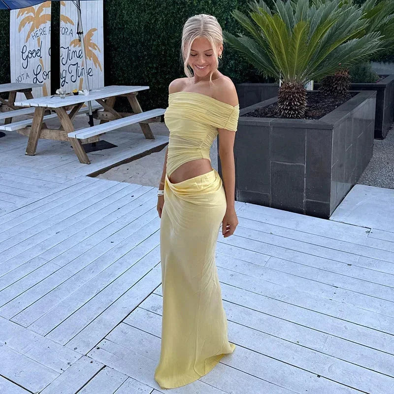 Robe longue fluide à épaules dénudées, froncée à la taille avec découpe, parfaite pour un look décontracté et élégant.