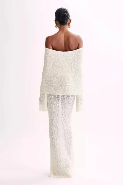 Robe longue à épaules dénudées en tissu texturé, avec manches longues et coupe fluide pour un style élégant et moderne.