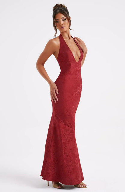 Robe longue rouge en tissu léger, col licou avec nœud, idéal pour une soirée élégante. Design fluide et texturé.
