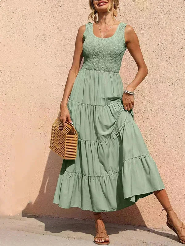 Robe longue sans manches en coton, smockée avec volants, idéale pour un look estival décontracté.