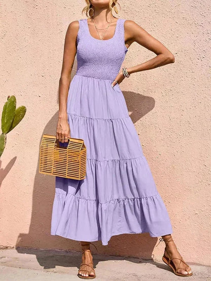 Robe longue sans manches en coton smocké avec volants, idéale pour les journées d'été. Modèle léger et fluide.