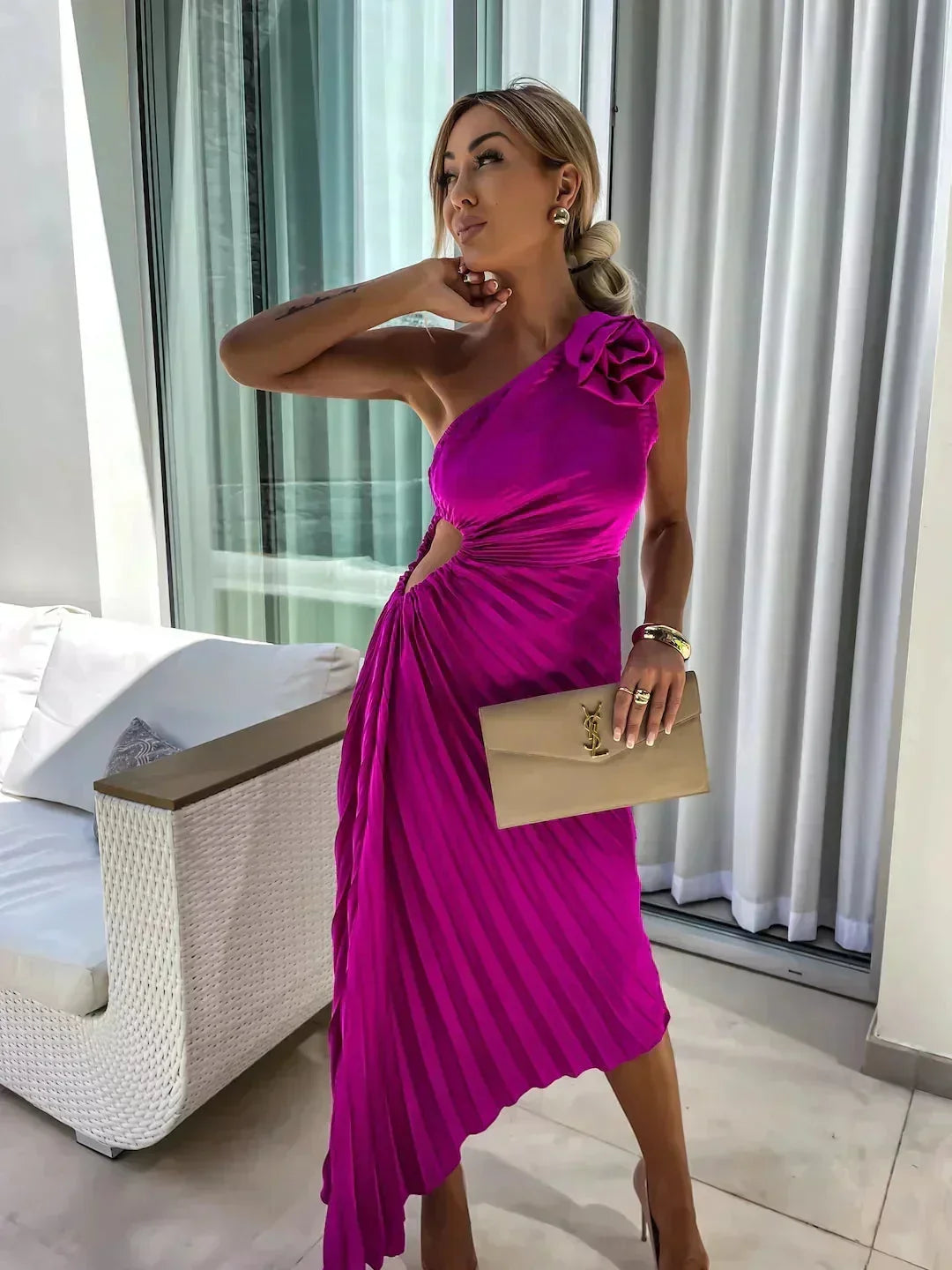 Robe midi asymétrique plissée en tissu léger, avec découpe moderne et motif floral rose, idéale pour des occasions spéciales.