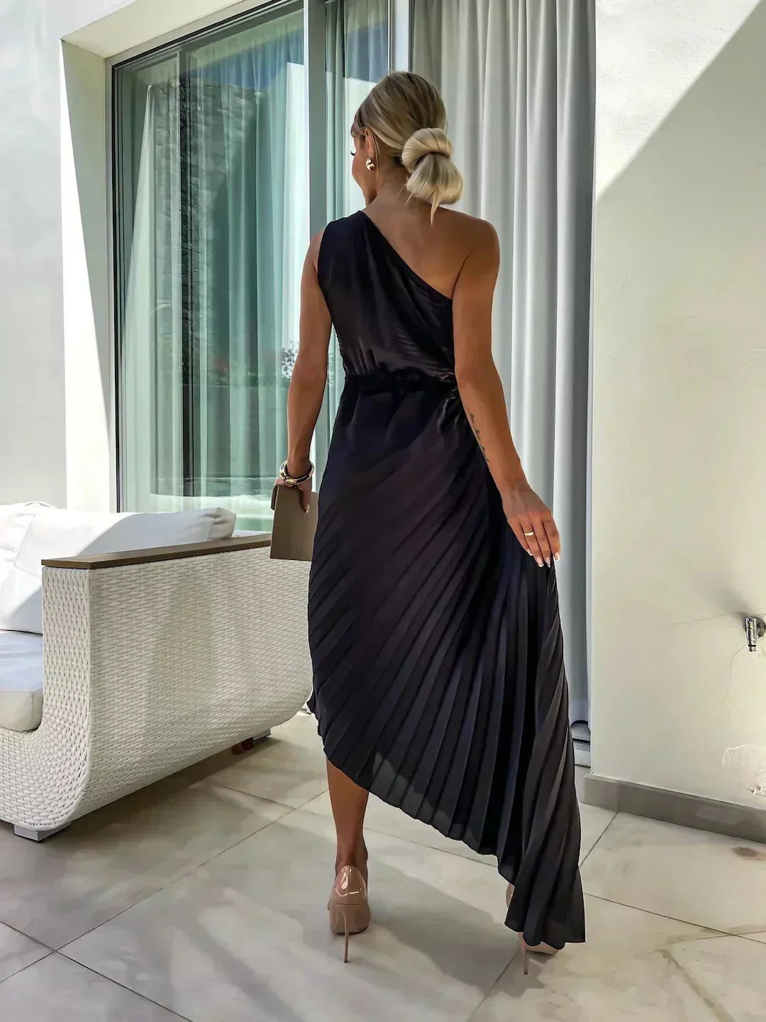 Robe midi plissée asymétrique en tissu léger, dotée de découpes élégantes et d'une teinte rose douce.