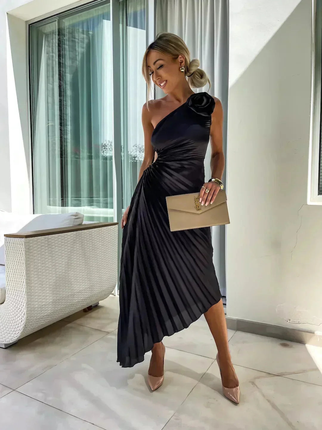 Robe midi asymétrique en noir, plissée avec découpe unique, confectionnée dans un tissu léger et fluide.