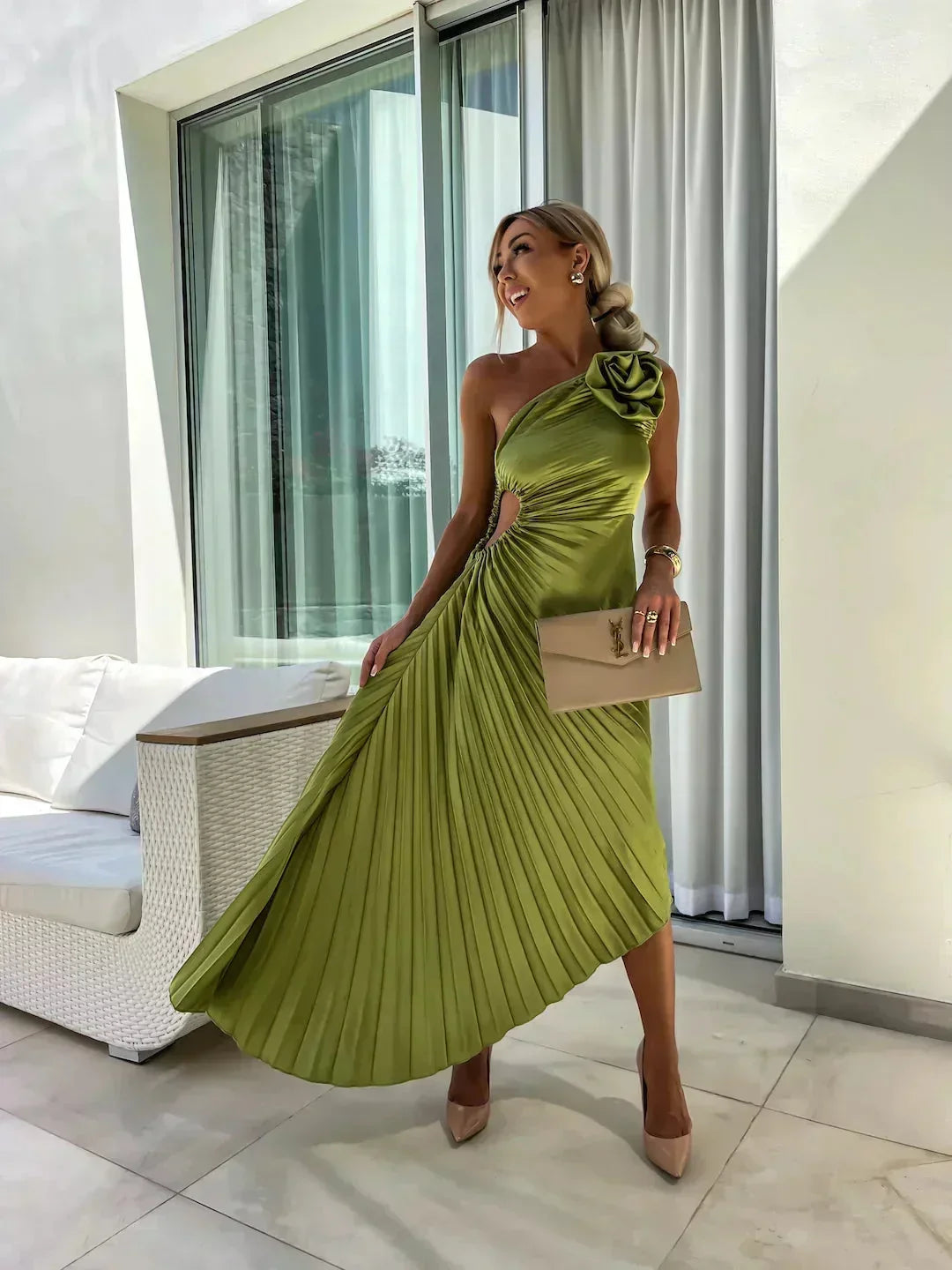 Robe midi asymétrique plissée en vert, avec découpe et détail rose, offrant un look moderne et une finition élégante.