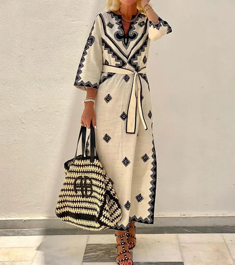 Robe midi beige en tissu léger, imprimée, ceinture à la taille, manches 3/4 et col en V, idéale pour l'été.