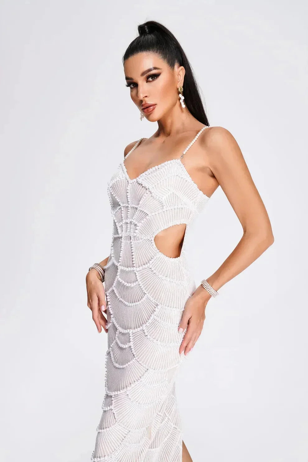 Robe midi blanche à sequins, bretelles découpées côtelées, parfaite pour les soirées. Matière légère et scintillante.