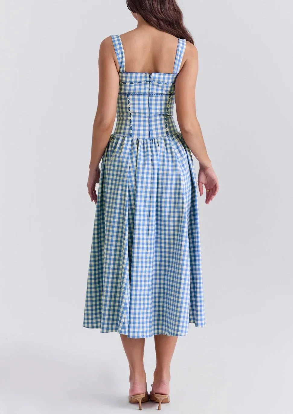 Robe midi bleu à carreaux vichy, épaules dénudées, en tissu léger idéal pour l'été, avec un design fluide et confortable.
