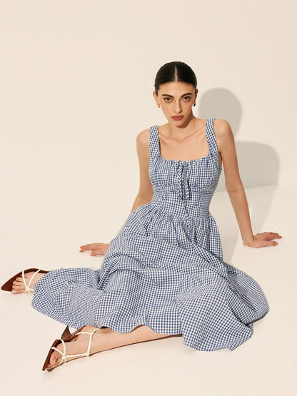 Robe midi sans manches à carreaux bleu marine, col carré, en tissu léger, idéale pour les journées d'été décontractées.