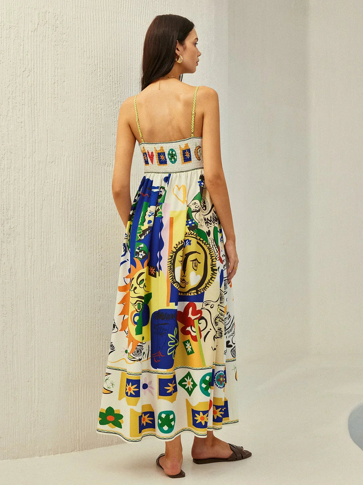 Robe midi colorée avec motifs ludiques, bretelles fines en tissu fluide parfait pour les journées ensoleillées.