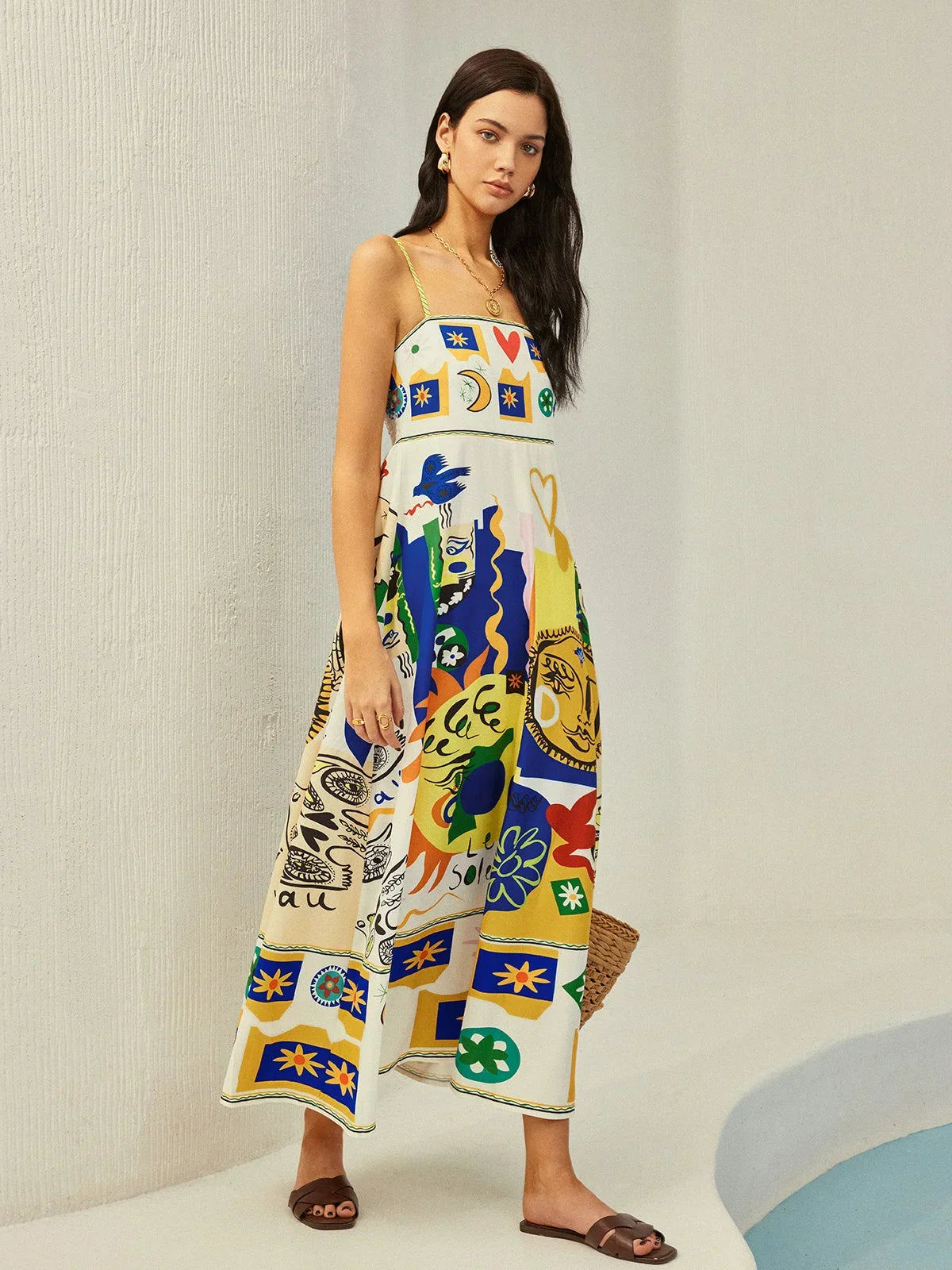 Robe midi en tissu fluide, motifs ludiques, bretelles fines, idéale pour une tenue décontractée et estivale.