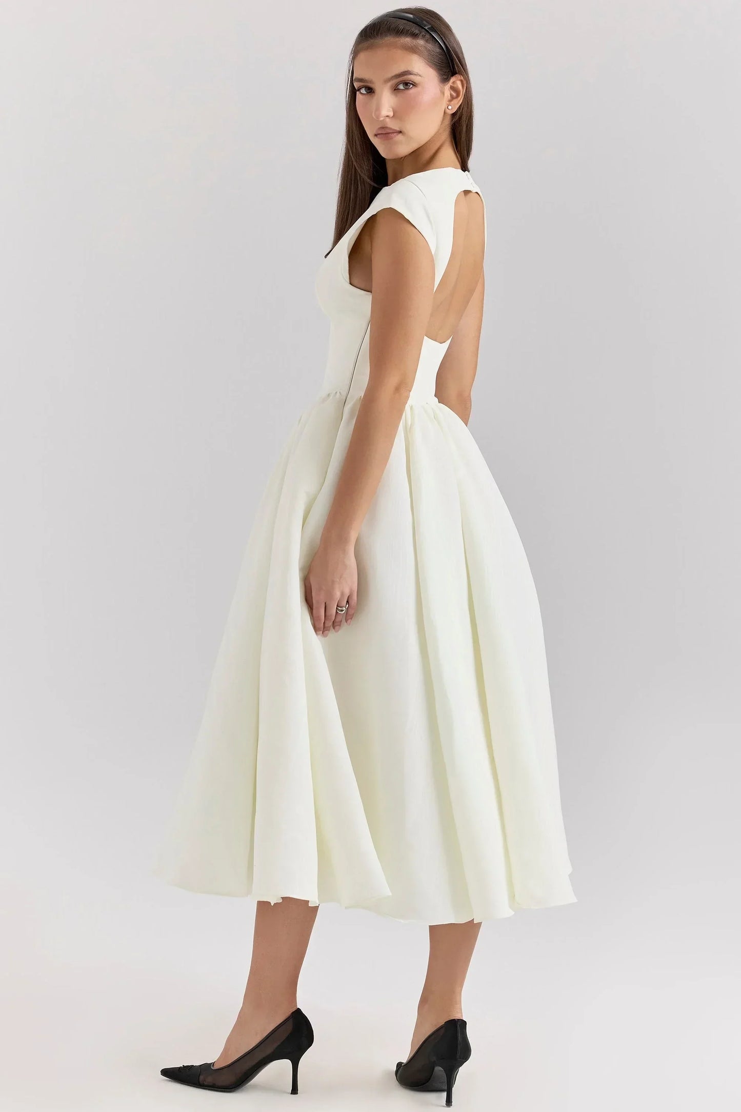 Robe midi en tissu fluide, coupe sculptée, manches courtes, col rond, jupe ample idéale pour des soirées élégantes.