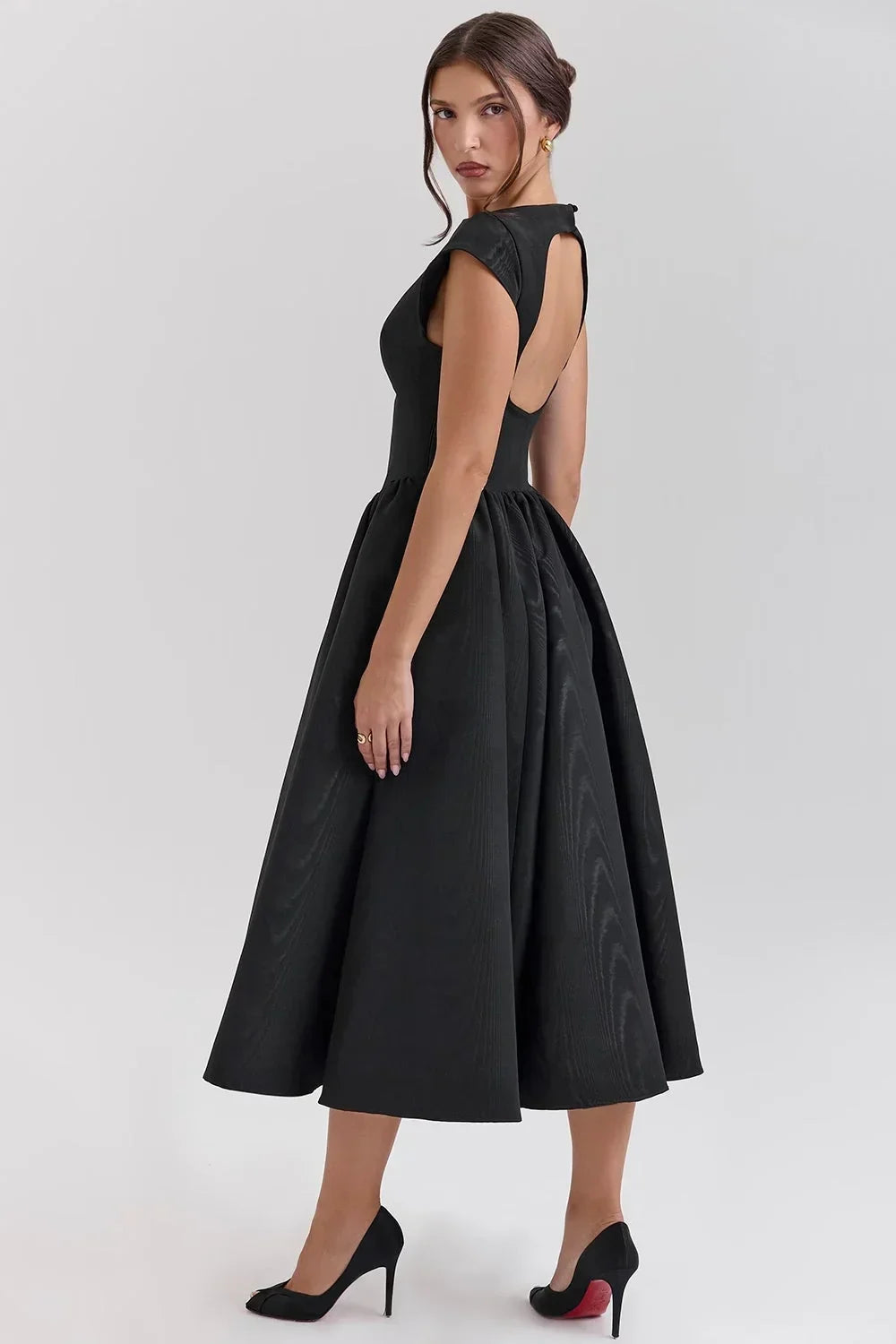 Robe midi sculptée avec manches courtes, col rond et jupe ample, en tissu fluide pour un confort optimal lors des soirées.