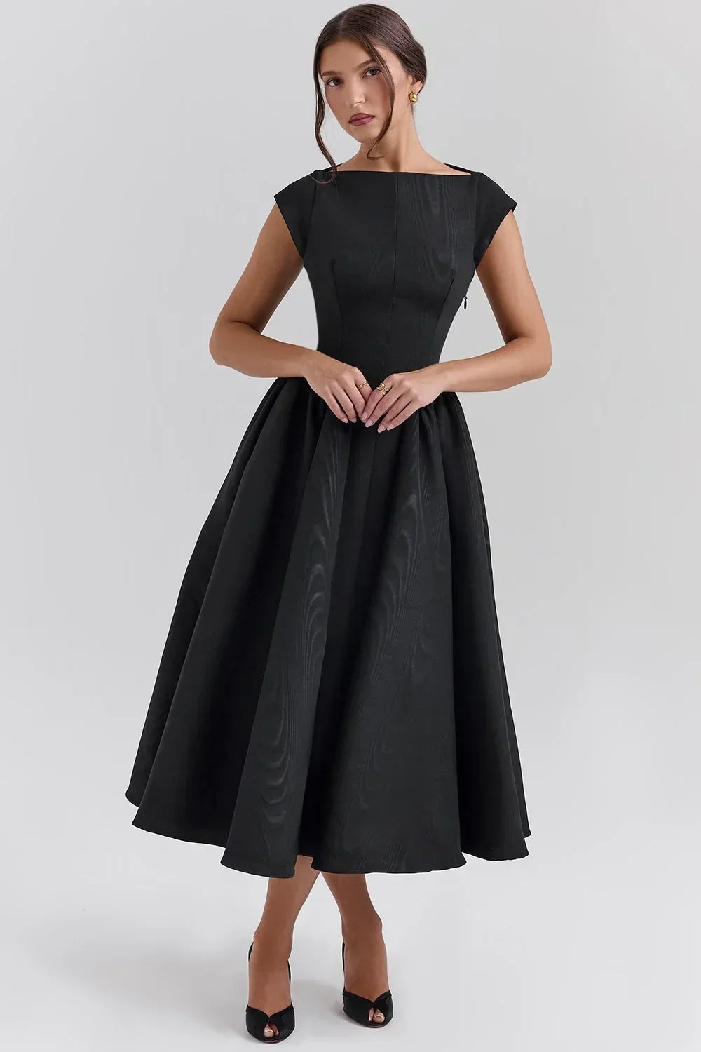 Robe midi sculptée en tissu léger, manches courtes, col rond, jupe ample, idéale pour les soirées élégantes.