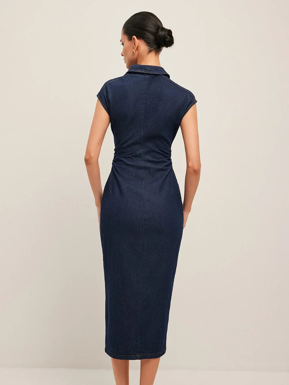 Robe midi en jean bleu foncé, sans manches, col V, avec une fermeture boutonnée sur le devant pour un look décontracté.