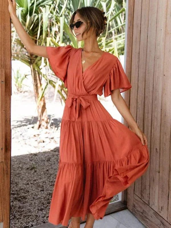 Robe midi ceinturée en tissu léger, volants au bas, col en V et manches courtes pour un look féminin et décontracté.