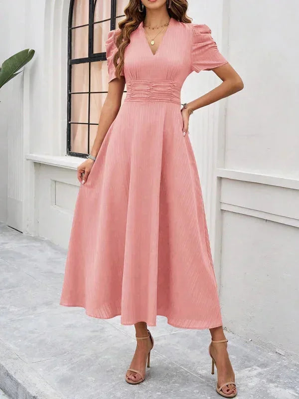 Robe midi femme en tissu léger avec col V et manches bouffantes, idéale pour les journées ensoleillées.