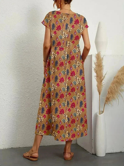 Robe midi en coton avec imprimé floral, manches courtes et poches latérales pratiques, idéale pour les journées ensoleillées.