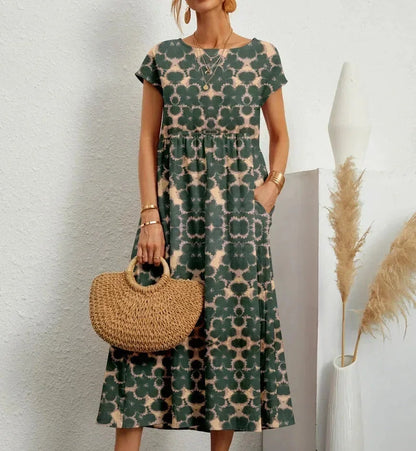 Robe midi verte en coton avec imprimé floral, dotée de poches pratiques et de manches courtes.