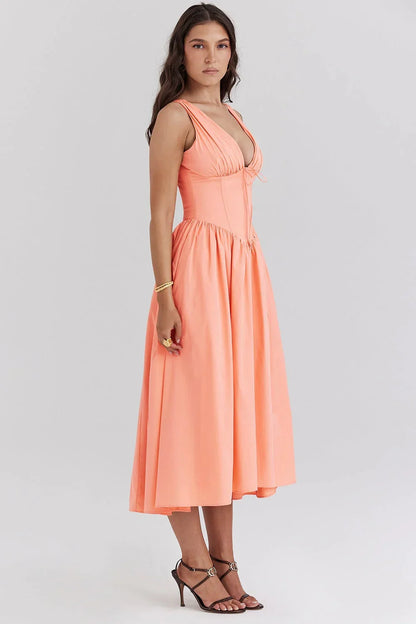 Robe midi femme fleurie sans manches en coton léger, avec un design floral et des couleurs pêche douces, parfaite pour l'été.