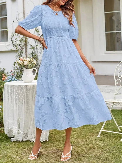 Robe midi femme en tissu texturé, manches courtes, avec volants délicats pour un look élégant et décontracté.