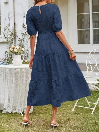 Robe midi femme en tissu texturé, à manches courtes et volants, idéale pour les journées décontractées et élégantes.