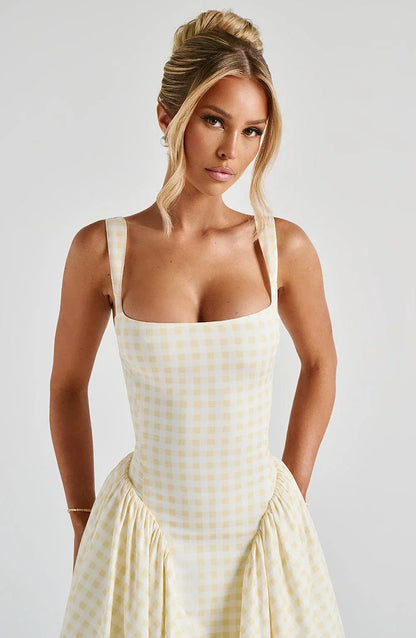 Robe midi évasée à carreaux, bretelles larges, en coton léger, idéale pour un look décontracté et élégant.