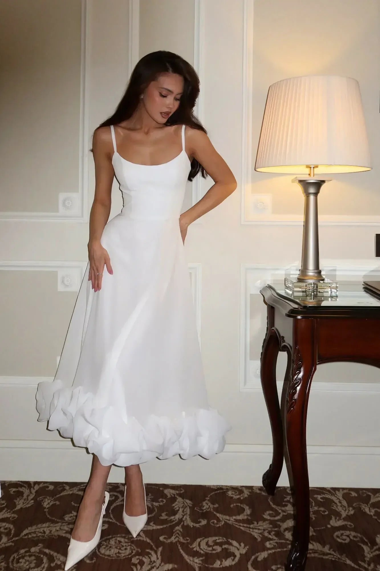 Robe midi sans manches en tissu léger, avec des volants délicats et une coupe fluide, idéale pour les journées ensoleillées.