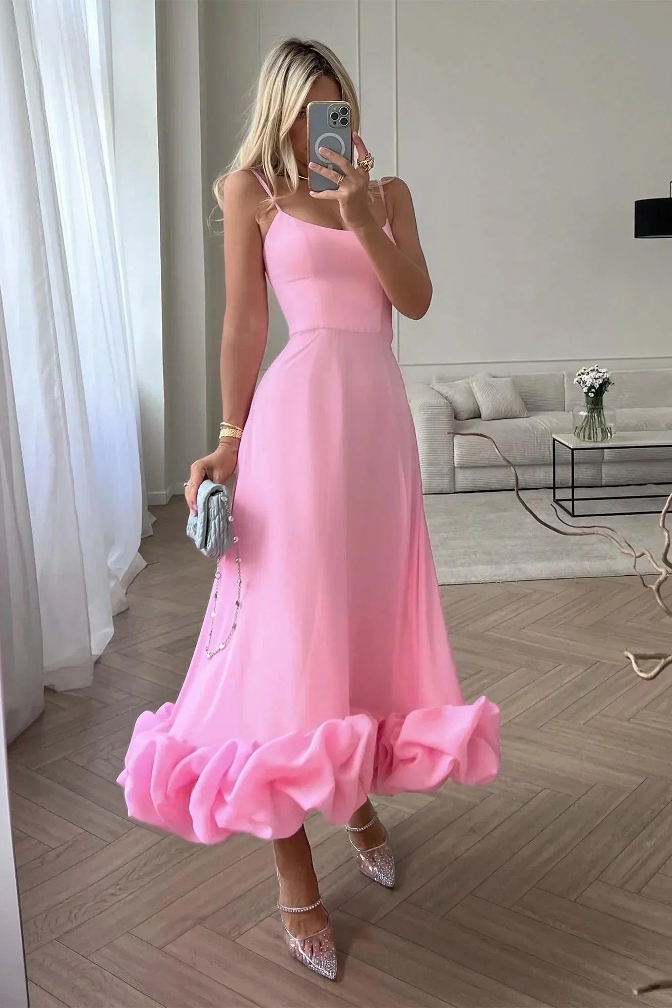 Robe midi rose sans manches avec volants, confectionnée en coton léger pour un style décontracté et féminin.