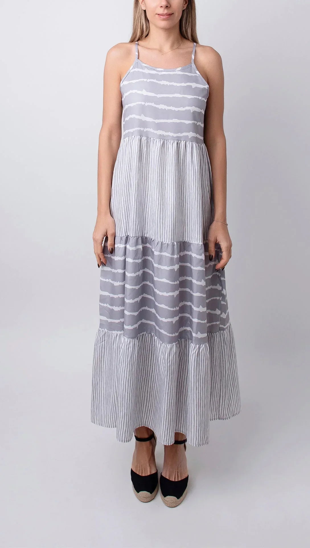 Robe midi grise sans manches, en coton léger, avec volants délicats pour une tenue estivale élégante et confortable.