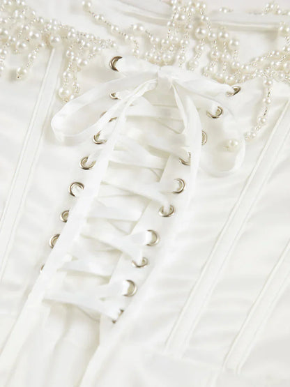 Robe midi ivoire en satin, bustier perlée et corset ajusté, idéale pour des soirées cocktails élégantes.
