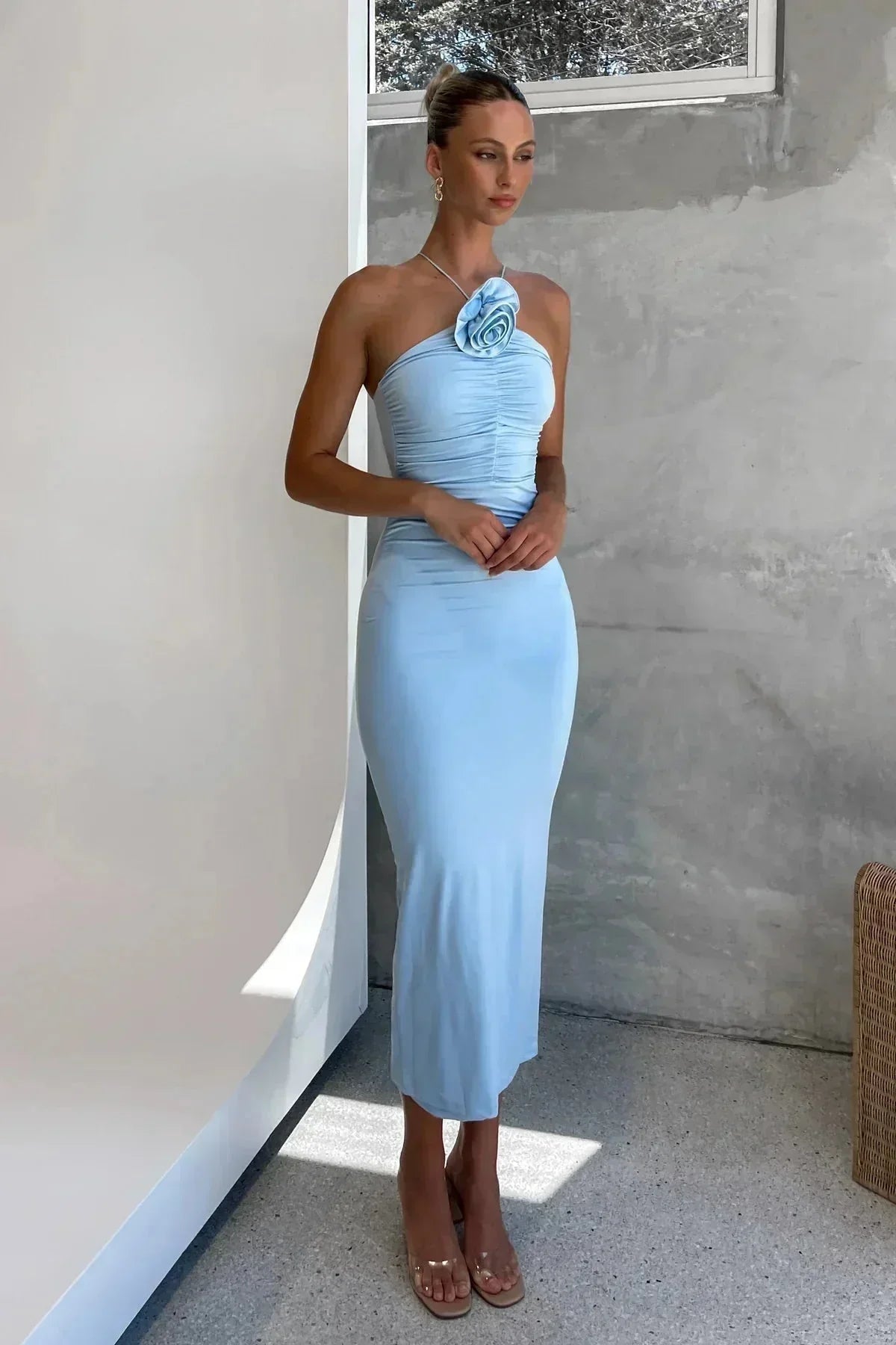 Robe midi moulante en tissu léger, avec des détails floraux et un col asymétrique sculptural pour une silhouette élégante.