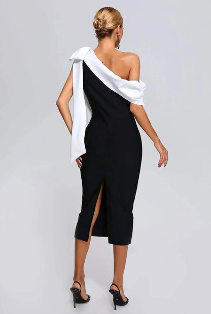 Robe midi noire et blanche, asymétrique à une épaule, en tissu léger avec nœud décoratif et coupe fluide.