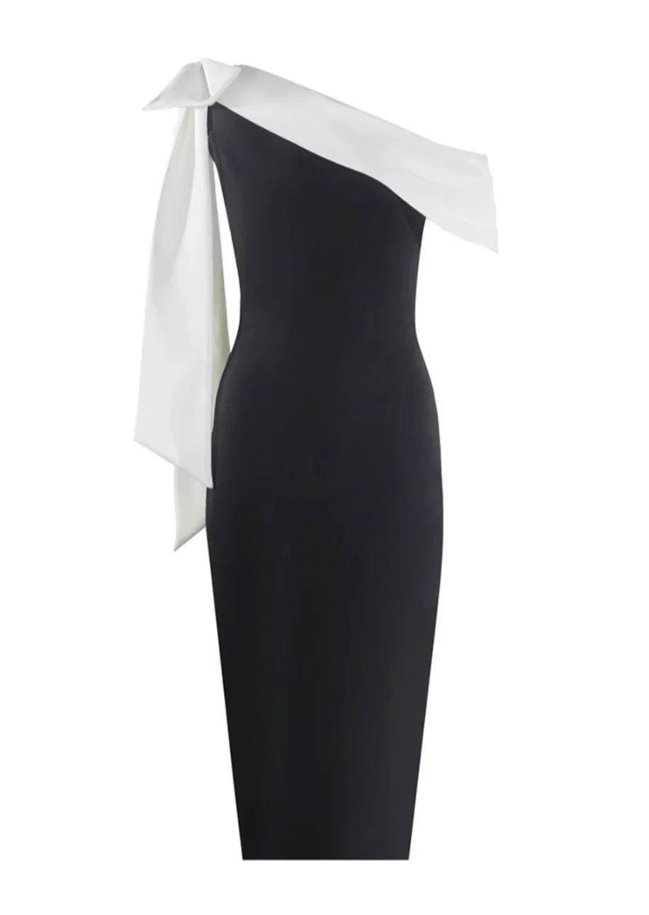 Robe midi noire et blanche, asymétrique à une épaule, en tissu léger avec un nœud décoratif sur l'épaule gauche.