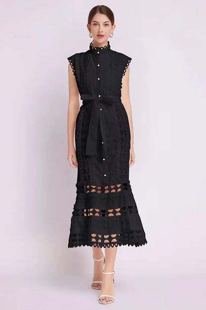 Robe midi noire sans manches en tissu léger, dotée de dentelle délicate et d'une ceinture ajustable pour un look élégant.