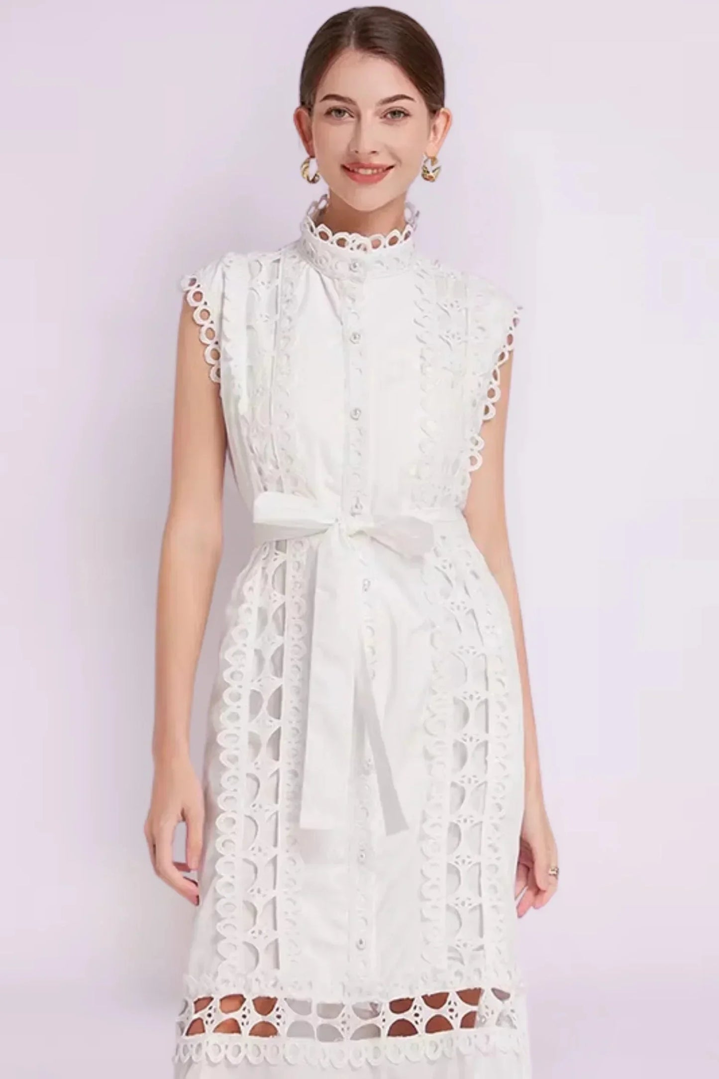 Robe midi noire sans manches en tissu léger, ornée de dentelle délicate et d'une ceinture ajustable pour un look élégant.