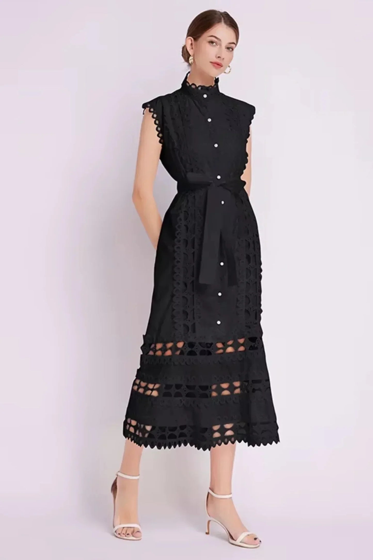 Robe midi noire sans manches en tissu léger, ornée de dentelle délicate et accompagnée d'une ceinture ajustable.