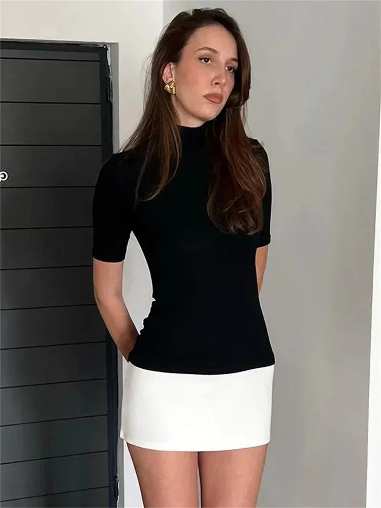 Robe courte bicolore bleu marine et blanc, col roulé, manches courtes, en matière légère pour un look décontracté.