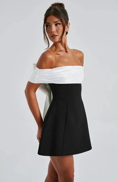 Robe courte bicolore avec épaules dénudées, nœud blanc à la taille, en tissu léger et fluide, idéale pour les soirées.