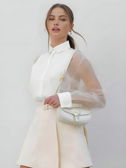 Robe courte blanche à manches longues en tissu transparent, col chemise, idéale pour une soirée cocktail chic.