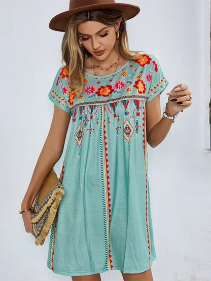 Robe courte bohème brodée à manches courtes, en tissu léger avec motifs floraux, idéale pour l'été et la plage.