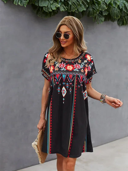 Robe courte bohème légère avec broderies florales et manches courtes, idéale pour l'été à la plage. Tissu aéré et confortable.