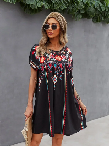 Robe courte bohème légère avec manches courtes, broderies florales pour l'été à la plage. Tissu aérien et coloré.