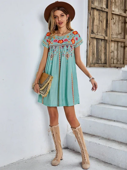 Robe courte bohème brodée à manches courtes, en tissu léger avec motifs floraux, idéale pour l'été et les journées à la plage.
