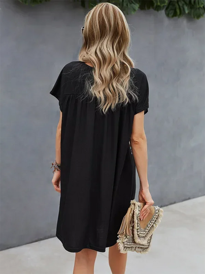 Robe courte bohème légère avec broderies florales et manches courtes, parfaite pour l'été à la plage.