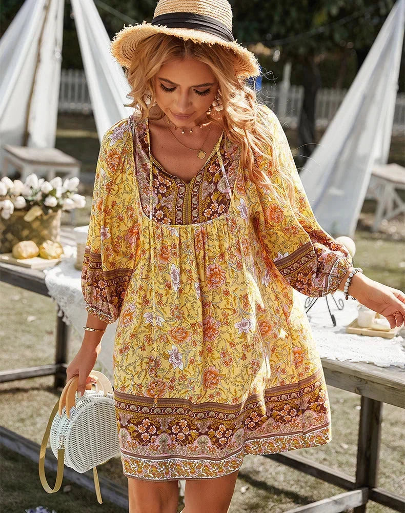 Robe courte bohème fluide avec imprimé coloré et manches longues, idéale pour un look décontracté estival.
