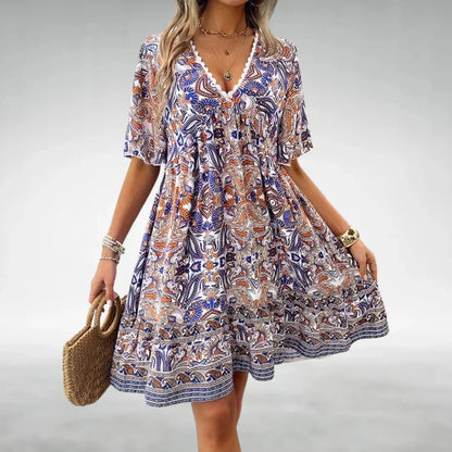 Robe courte bohème à motifs, avec col à cordon, légère et idéale pour la plage en été. Fabriquée en coton agrémenté.