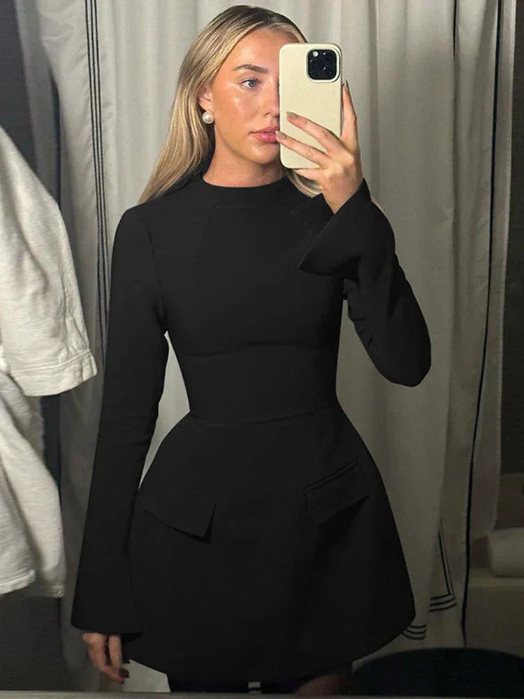 Robe mini noire pour femme, en tissu doux, avec poches intégrées et manches longues pour un style pratique et confortable.